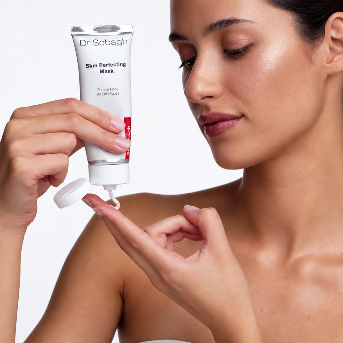 Model squeezing Dr Sebagh Skin Perfecting Mask onto her fingertips