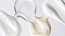 Three Dr Sebagh skincare textures swirled together: a clear gel droplet, a pearlescent cream and an ivory balm on a pale grey background