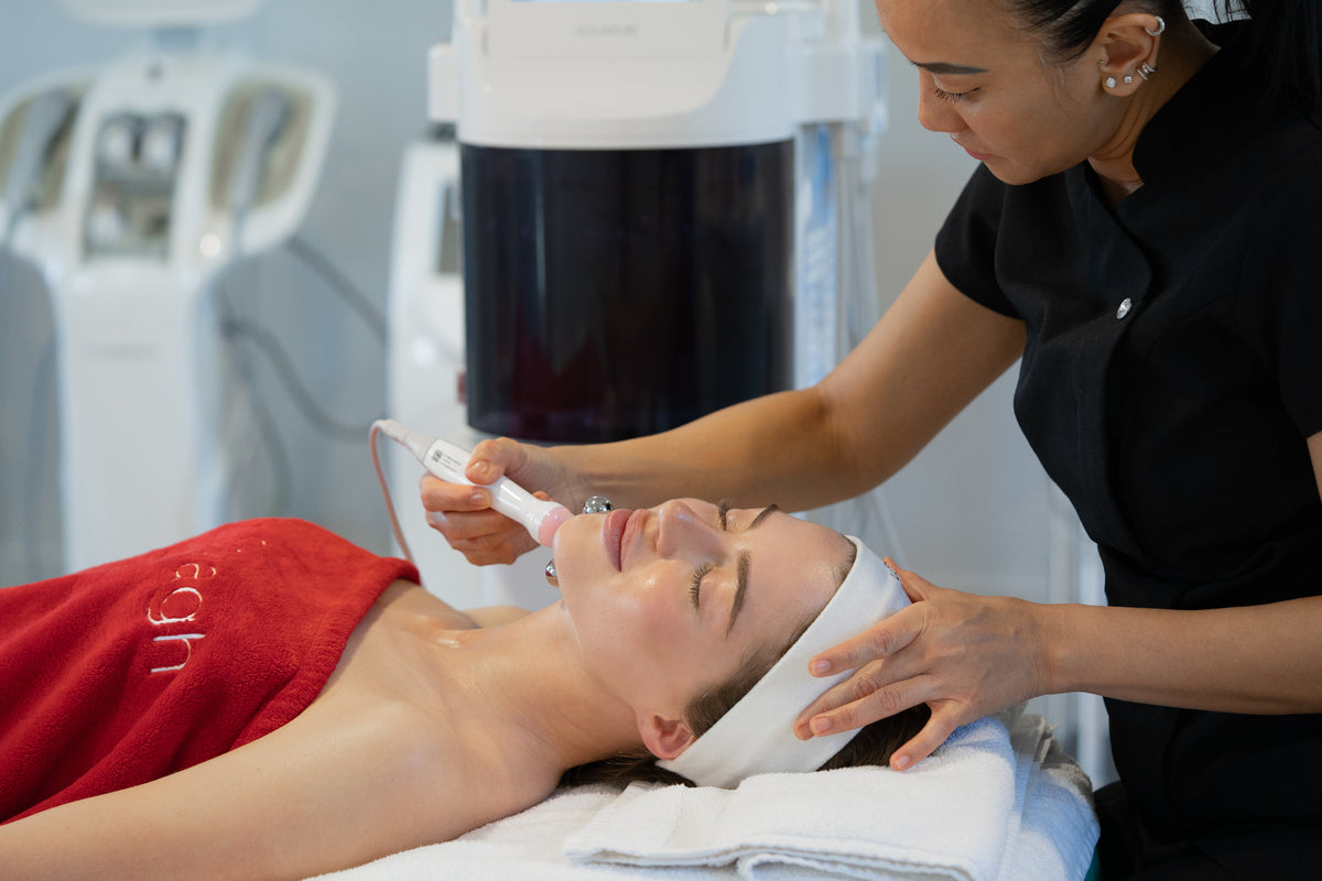 Dr Sebagh therapist performing an Aquapure facial, using a handheld device on a client's face in the clinic