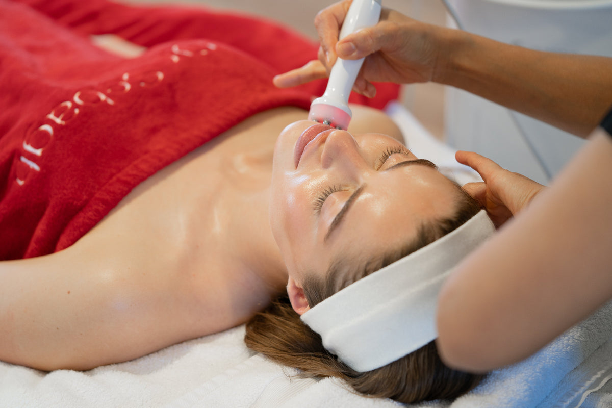 Close-up of the Aquapure facial handpiece being used on a client's lower face during treatment