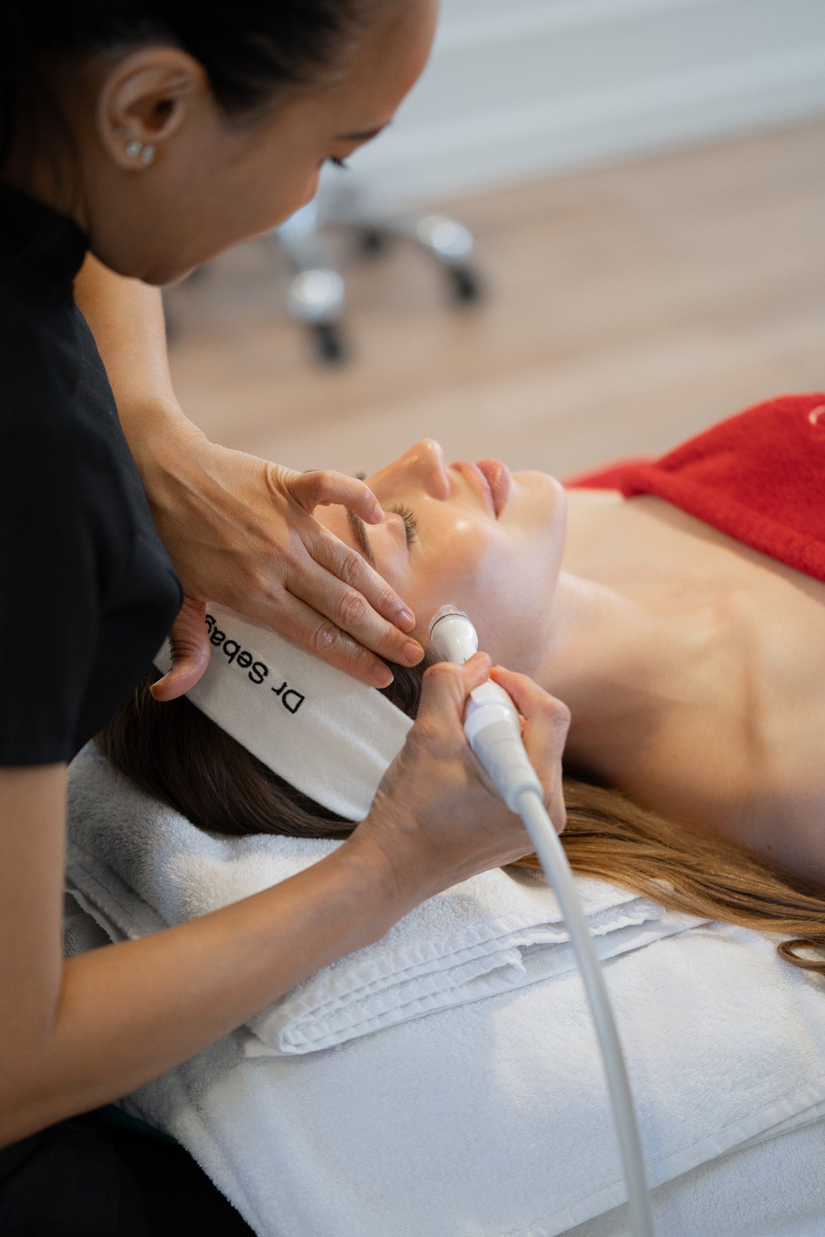 Dr Sebagh therapist giving an Aquapure facial, guiding the handpiece along a client's jawline