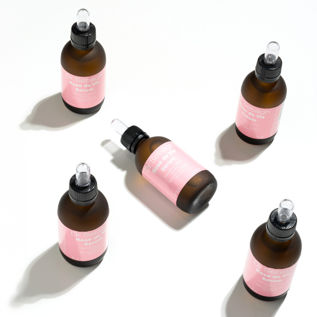 Flat lay of multiple Dr Sebagh Rose de Vie Serum bottles with droppers, showcasing the nourishing anti-ageing serum.