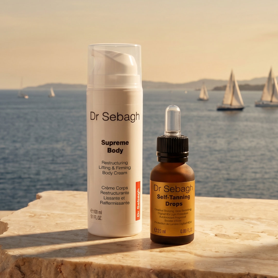Dr Sebagh Supreme Body and Self-Tanning Drops products on a wooden surface with a scenic background of water and sailboats.